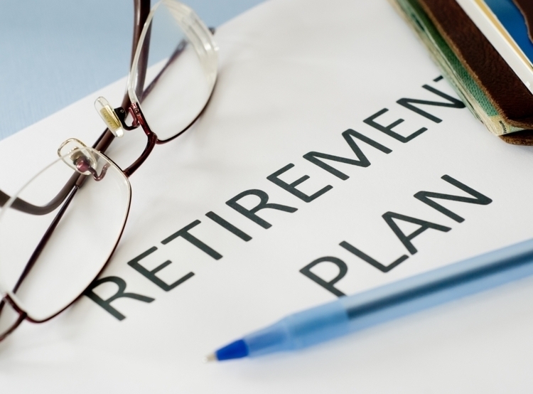 a document reading: retirement plan with glasses sitting on top